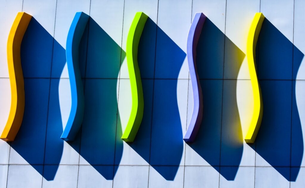 Abstract blue shapes with colorful edges against a wall